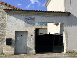 Charmante bâtisse en pierre à Angoulême, avec sa voûte et sa porte grise, et son enseigne « Chocolat » ; une chambre d’hôtes idéale en Charente.
