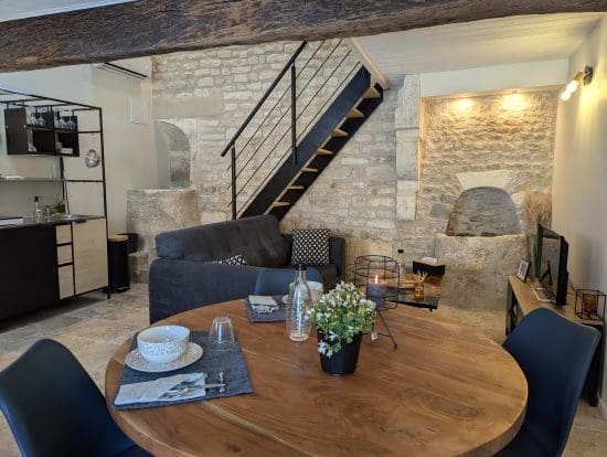 Charmant salon aux allures de maison d'hôtes à Angoulême : pierres de Charente, table rustique, cuisine équipée, ambiance chaleureuse.
