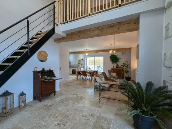 Salon lumineux et chaleureux d'une maison d'hôtes à Angoulême, avec poutres apparentes de style charentais, cuisine ouverte et décoration conviviale.