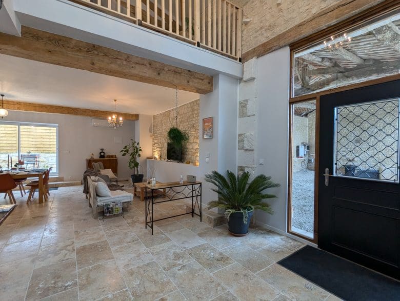 Salon chaleureux d’une maison d’hôtes en Charente, pierres claires, poutres apparentes près d’Angoulême, charme authentique.