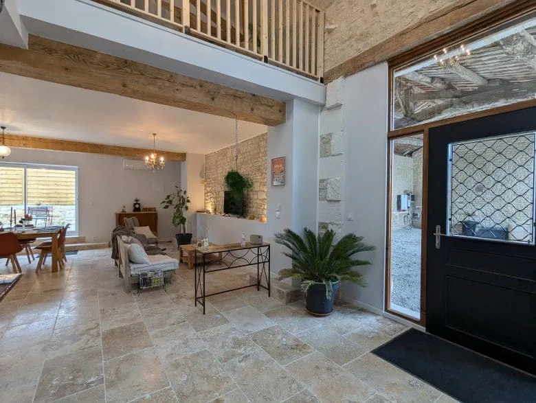 Salon chaleureux d’une maison d’hôtes en Charente, pierres claires, poutres apparentes près d’Angoulême, charme authentique.