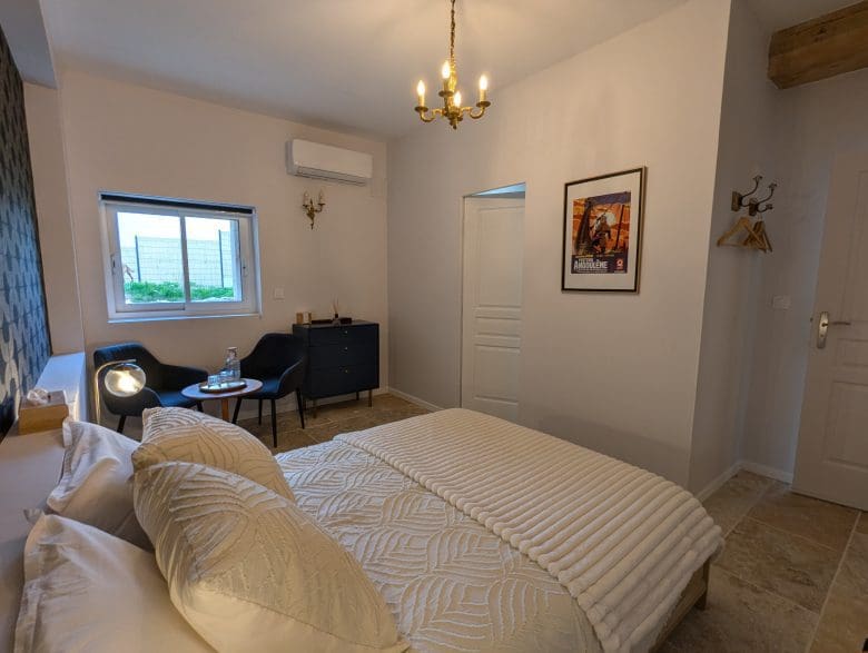 Une chambre d’hôtes chaleureuse à Angoulême, avec un lit douillet, un coin salon lumineux, une décoration charentaise moderne et une ambiance raffinée.