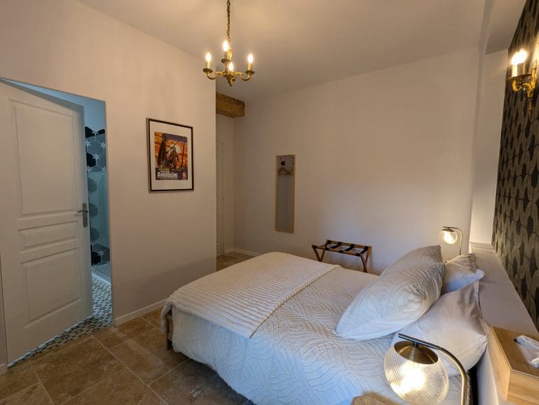 Chambre d’hôtes chaleureuse en Charente, à Angoulême : lit double, décoration soignée, salle de bains ouverte, sols carrelés et charme authentique.