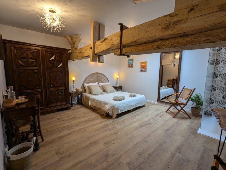 Chambre d’hôtes douillette en Charente, poutres apparentes, lit king-size, décoration rustique, ambiance chaleureuse à Angoulême.