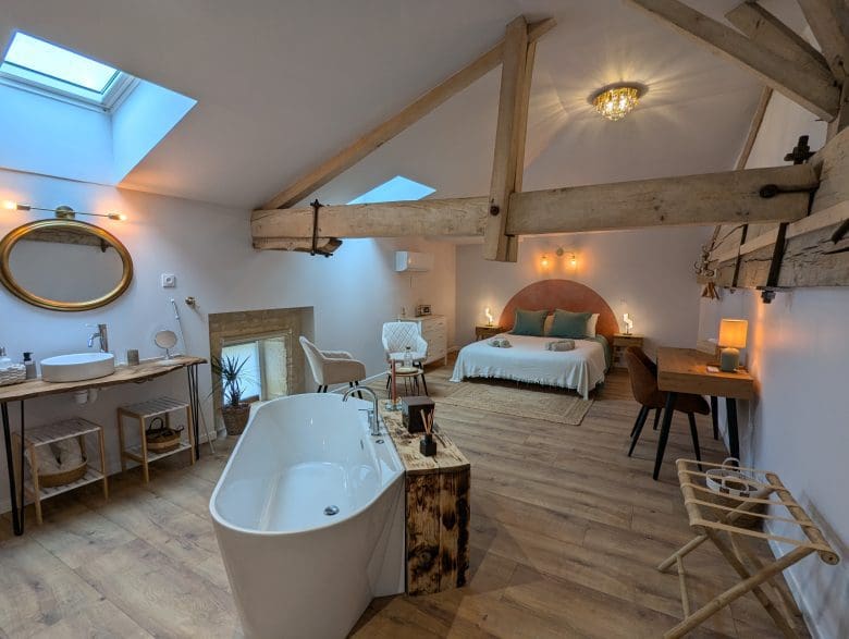 Chambre d’hôtes chaleureuse près d’Angoulême, poutres charentaises, baignoire îlot, lit double, lumière naturelle et décoration chaleureuse.