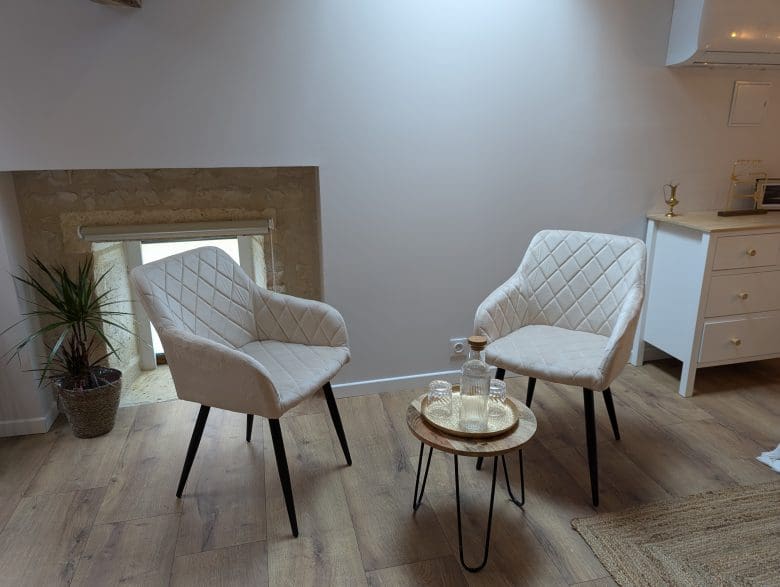 Dans un salon chaleureux d’Angoulême, en Charente, deux fauteuils blancs se font face près d’une table en bois aux lignes élégantes.