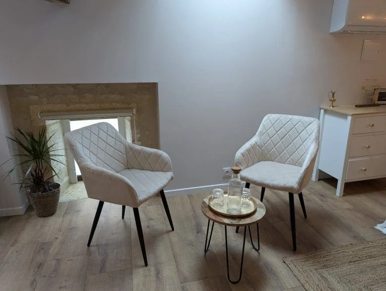 Dans un salon chaleureux d’Angoulême, en Charente, deux fauteuils blancs se font face près d’une table en bois aux lignes élégantes.