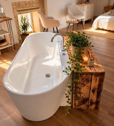 Baignoire moderne sur parquet, décoration rustique et chaleureuse en Charente, lit douillet et table d’hôtes près d’Angoulême.