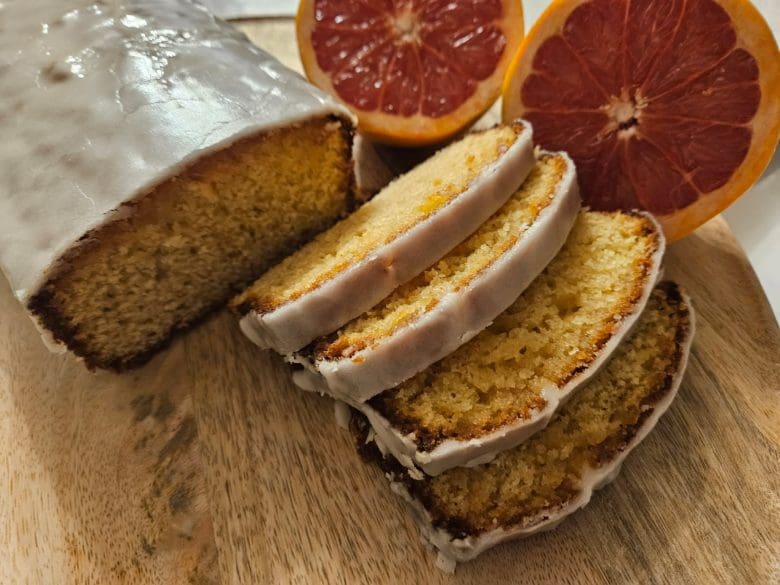 Un délicieux gâteau aux agrumes servi en tranches sur une planche, des oranges sanguines et une ambiance chaleureuse à Angoulême, en Charente.