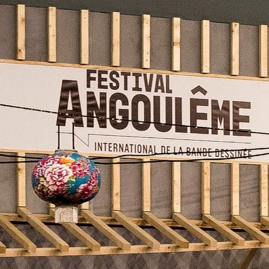 Panneau « Festival Angoulême Bande Dessinée » sur bois, lanterne fleurie ; ambiance chaleureuse typique de la Charente à Angoulême.
