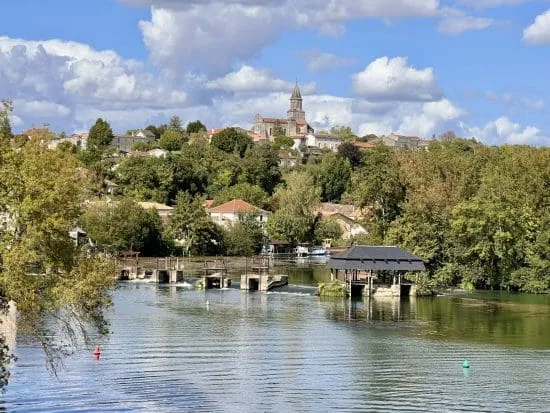 Découvrez le charme de la Charente avec une vue imprenable sur la rivière paisible, un petit embarcadère accueillant entouré d’arbres verdoyants, et un village pittoresque à flanc de colline dominé par le clocher emblématique d’une église, sous un ciel bleu parsemé de nuages. Profitez de ce cadre authentique près d’Angoulême pour un séjour chaleureux en maison d’hôtes au cœur du paysage charentais.